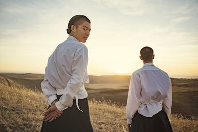 Man and woman standing on field against sky