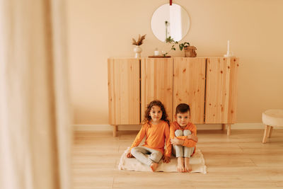 Small children friends brother and sister in home clothes play together in children's room at home