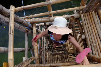 High angle view of young woman standing on wooden structure