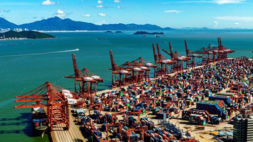 High angle view of commercial dock by sea against sky