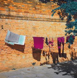 Clothes drying against brick wall