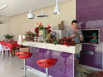 Man cutting flowers in shop for sale