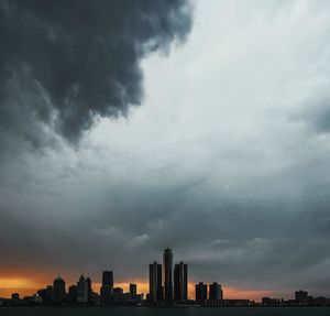 Skyscrapers in city against cloudy sky