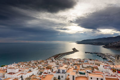 High angle view of townscape by sea against sky