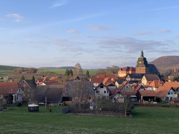 Houses on field by buildings against sky in ershausen, schimberg, eichsfeld, thuringia, germany