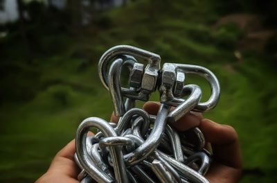 Close-up of person holding chain