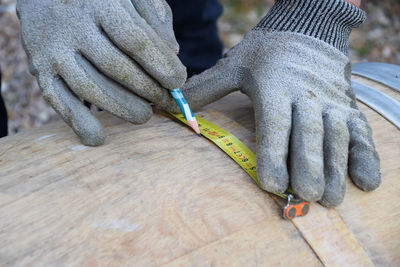 Cropped image of worker working on wood with tools