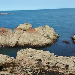 Rock formation on beach against sky