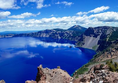 Panoramic view of sea and mountains against blue sky