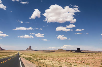 Panoramic view of road amidst field against sky