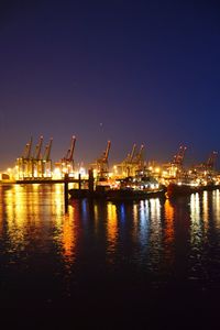 Illuminated commercial dock against sky at night