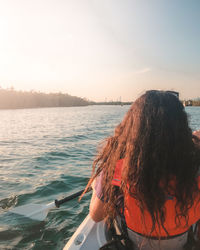 Rear view of woman looking at sea against sky