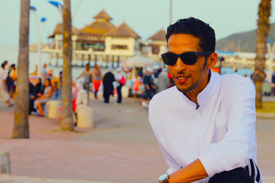 Portrait of young man wearing sunglasses standing outdoors