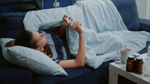 Couple using digital tablet while sitting on bed at home