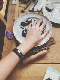 High angle view of woman hand on wooden table