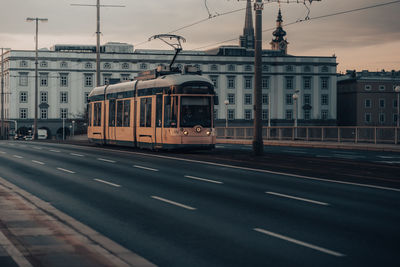 Train on railroad track in city against sky