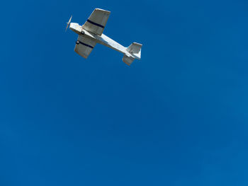 Low angle view of a plane against blue sky