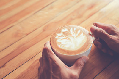 Cropped image of hand holding coffee cup