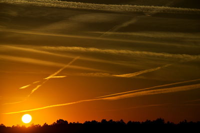 Scenic view of vapor trails in sky during sunset