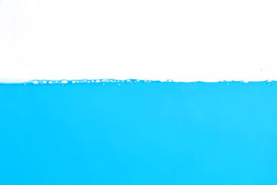 Close-up of drink over water against white background
