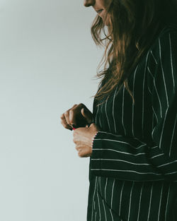 Midsection of young woman using mobile phone