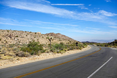 Road amidst landscape against blue sky