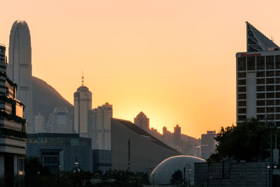 Modern buildings against sky during sunset