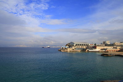 Scenic view of sea by buildings against sky