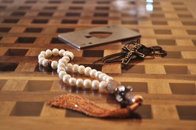 Close-up of tasbih and rosary on floor