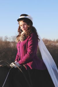 Portrait of girl riding a horse against sky