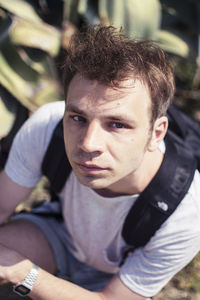 High angle portrait of man sitting on field