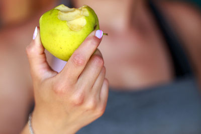 Midsection of woman holding granny smith apple