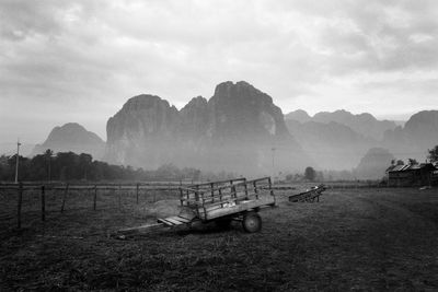 Wooden push carts on field against mountains