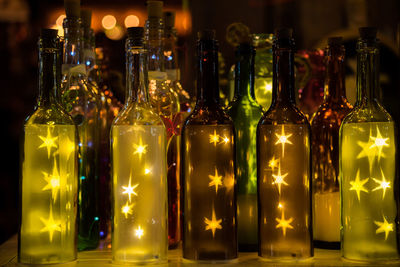 Close-up of illuminated wine bottles