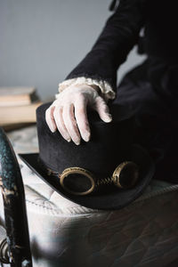 Close-up of woman touching hat on bed