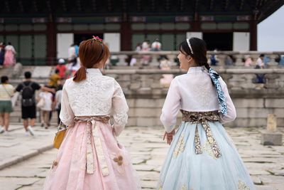 Rear view of women standing on walkway