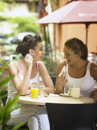 Happy female friends having breakfast at outdoor restaurant