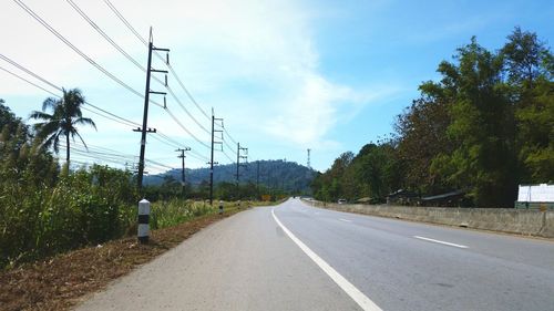 Road amidst trees against sky