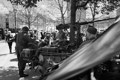 Army soldiers by military land vehicle on street in city