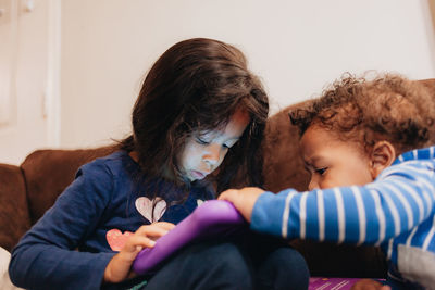 Cute kids playing on sofa at home