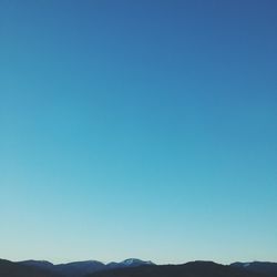 Scenic view of mountains against clear blue sky