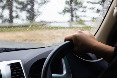 Midsection of woman seen through car window