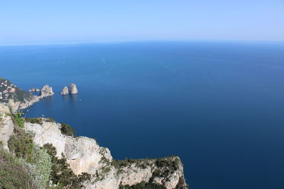 High angle view of rocks by sea against sky