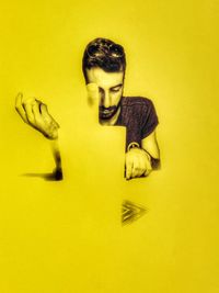 Portrait of young man against yellow background