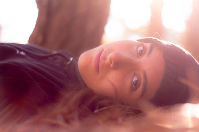 Portrait of smiling young woman lying outdoors