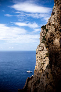 Rock formations by sea against sky