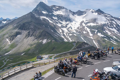 Group of people on road against mountain range