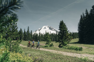 Threee women bike on a trail near mt. hood in oregon.