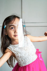 A toddler girl wearing the face protection shield. a safety corona mask during covid-19 pandemic.