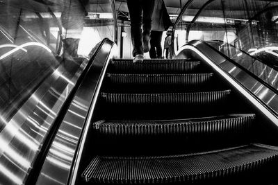 Low angle view of people moving up on escalator